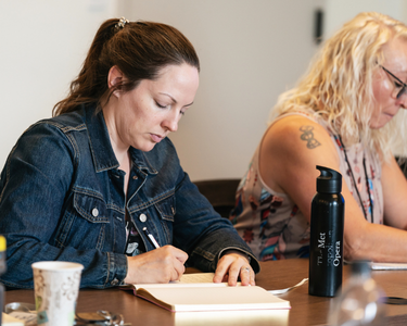 Image of someone writing in their notebook
