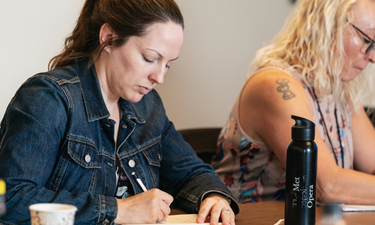 Image of someone writing in their notebook